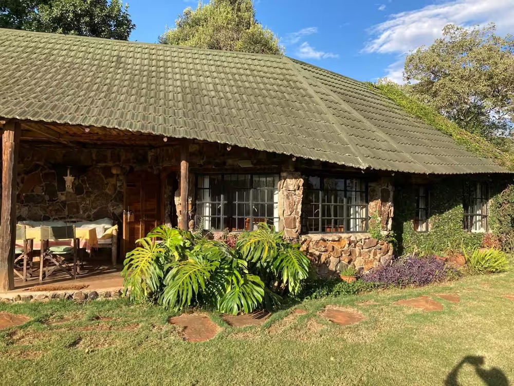 Mutamaiyu Cottage: stone walls, green tiled roof and veranda